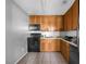 Galley style kitchen with wood cabinets, black appliances, and tile flooring at 3954 Versailles Dr # 3954B, Orlando, FL 32808