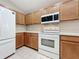 Kitchen with wood cabinets, white appliances and tile floor at 425 Tree Shore Dr, Orlando, FL 32825