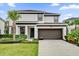 Two-story home with a modern design, two-car garage, and landscaped lawn at 4571 Cabello Loop, Kissimmee, FL 34746