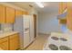 Efficient kitchen with wood cabinets, white appliances, and tile floors at 547 Hunter Cir # 547, Kissimmee, FL 34758