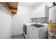 Bright laundry room with washer, dryer, cabinets, and overhead storage at 10637 Deergrass Ln, Orlando, FL 32821