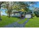 Gray house with a white garage, red door and nicely landscaped lawn at 20 Maynard Ave, Orlando, FL 32803