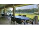 Community patio with tables and chairs overlooking tennis courts at 324 Valley Dr, Longwood, FL 32779