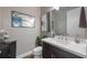 Modern powder room with dark vanity, white countertop, and elegant mirror at 3867 Grassland Loop, Lake Mary, FL 32746