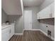 Bright laundry room with white cabinets and wood-look floors at 3867 Grassland Loop, Lake Mary, FL 32746