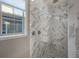 Elegant shower with marble tile, multiple shower heads, and a bench seat at 3867 Grassland Loop, Lake Mary, FL 32746