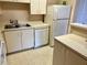 A corner kitchen with white appliances and light-colored cabinets at 485 Forestway Cir # 202, Altamonte Springs, FL 32701