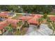 Aerial view showcasing a community of homes with red tile roofs and lush greenery at 5027 Jamaica Cir # 7, Orlando, FL 32808