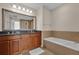 Elegant bathroom featuring double vanity, soaking tub, and large mirror at 7612 Sandy Ridge Dr # 304, Kissimmee, FL 34747