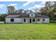 White farmhouse exterior with a large yard and covered porch at 8827 Sw 137Th Ct, Ocala, FL 34481