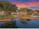 Tranquil backyard with illuminated putting green and lake views at sunset at 100 Blue Lake Ct, Longwood, FL 32779