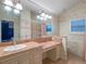 Spacious bathroom with double vanity, large mirror, and tiled shower at 100 Blue Lake Ct, Longwood, FL 32779