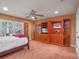 Bedroom with wooden built-in entertainment center, ceiling fan, and plantation shutters at 100 Blue Lake Ct, Longwood, FL 32779