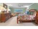 Large bedroom with wooden furniture, floral bedding, and plush carpeting at 100 Blue Lake Ct, Longwood, FL 32779