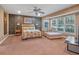 Bedroom with ceiling fan, plush carpeting, chaise lounge, and large windows at 100 Blue Lake Ct, Longwood, FL 32779