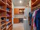 Spacious walk-in closet in the primary bathroom featuring built-in shelving and washer/dryer at 100 Blue Lake Ct, Longwood, FL 32779