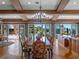 Dining area with stylish chandelier, backyard views, and pool access at 100 Blue Lake Ct, Longwood, FL 32779
