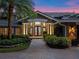 Front entrance of a home with a decorative glass door, columns, and landscaping at 100 Blue Lake Ct, Longwood, FL 32779