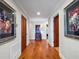 Long hallway with hardwood floors, artwork, and doorways to other rooms at 100 Blue Lake Ct, Longwood, FL 32779