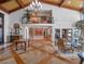 Living area with fireplace, high ceilings, wood beams, and a second-floor balcony at 100 Blue Lake Ct, Longwood, FL 32779