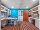 Bright home office with white built-in shelving, dual desks, and striped carpeting at 100 Blue Lake Ct, Longwood, FL 32779