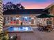 Backyard patio with spa, outdoor dining area, and views into the home's interior at 100 Blue Lake Ct, Longwood, FL 32779