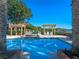 Tranquil pool area with pergola-covered seating area and beautiful waterfront views at 100 Blue Lake Ct, Longwood, FL 32779