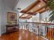 Upstairs hallway with wood floors, decorative railing, and view of the living room below at 100 Blue Lake Ct, Longwood, FL 32779