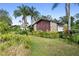 Attached garage with stone and wood exterior, surrounded by tropical landscaping at 107 Maplewood Dr, Sanford, FL 32771