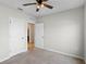 Bedroom with ceiling fan, carpet flooring, and access to bathroom and hallway at 1224 Golden Eagle Ln, Winter Haven, FL 33880