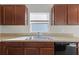 Kitchen features dark brown cabinets, stainless steel sink, and dishwasher at 1224 Golden Eagle Ln, Winter Haven, FL 33880