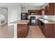 Modern kitchen with island, dark wood cabinets, and black appliances at 1224 Golden Eagle Ln, Winter Haven, FL 33880