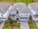 An aerial view showcasing a two-story house with gray tile roofing and a paved driveway at 1670 Moon Valley Dr, Davenport, FL 33896