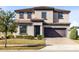 Two-story house with brown roof, two-car garage, and landscaped lawn at 181 Brookes Pl, Haines City, FL 33844