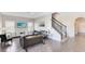 Bright living room with tile floors, gray couch, and staircase at 181 Brookes Pl, Haines City, FL 33844