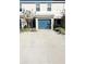 Two-story townhome with a teal garage door and landscaping at 2906 Fieldwood Cir, St Cloud, FL 34772