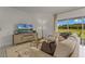 Bright living room features a comfy sofa, large TV, and sliding glass doors leading to a backyard view at 3331 Private Oak Dr, Apopka, FL 32703