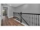 Elegant staircase with black wrought iron railing and wood flooring at 8169 Roseville Rd, Davenport, FL 33896