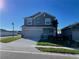 Two-story house with gray siding, two-car garage, and landscaping at 247 Villavista Ct, Davenport, FL 33896