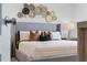 Main bedroom with gray upholstered bed and unique wall decor at 3313 Private Oak Dr, Apopka, FL 32703