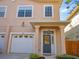 Tan two-story home with attached garage and a gray front door at 336 E Kaley St, Orlando, FL 32806
