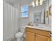 Light and airy bathroom with wood vanity and window at 4473 Davos Dr, Clermont, FL 34711