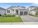 Two-story home with gray two car garage and landscaped front yard at 4473 Davos Dr, Clermont, FL 34711