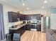 Modern kitchen with dark cabinets, granite counters, and stainless steel appliances at 604 Madison Dr, Davenport, FL 33837