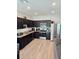 Modern kitchen with dark cabinets, granite counters, and stainless steel appliances at 604 Madison Dr, Davenport, FL 33837