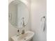 Small bathroom with a round mirror and a single sink at 11838 Deer Path Way, Orlando, FL 32832