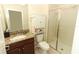 Clean bathroom with granite countertop, shower and a storage cabinet at 15121 Evergreen Oak Loop, Winter Garden, FL 34787