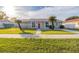 Gray house with red door, landscaping, and driveway at 224 Jalapa Dr, Kissimmee, FL 34743