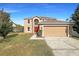 Two story house with a red door and attached garage at 7 Bolton Ct, Kissimmee, FL 34758