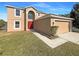 Two story house with a red door and attached garage at 7 Bolton Ct, Kissimmee, FL 34758